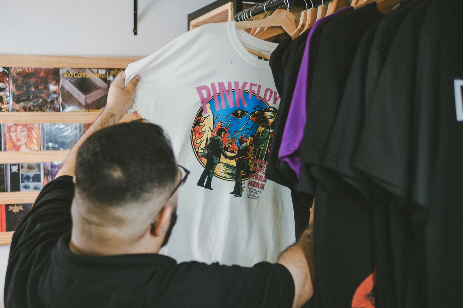 Cliente escolhendo camisa de banda